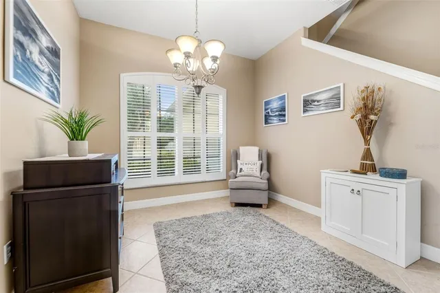 a living room with furniture a chandelier and a window