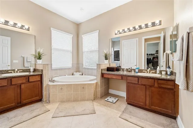 a bathroom with a tub sink and mirror
