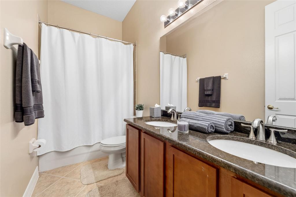 4460 Birchfield Loop Spring Hill, FL 34609 - Photo 27 of 38 a bathroom with a double vanity sink toilet and a mirror