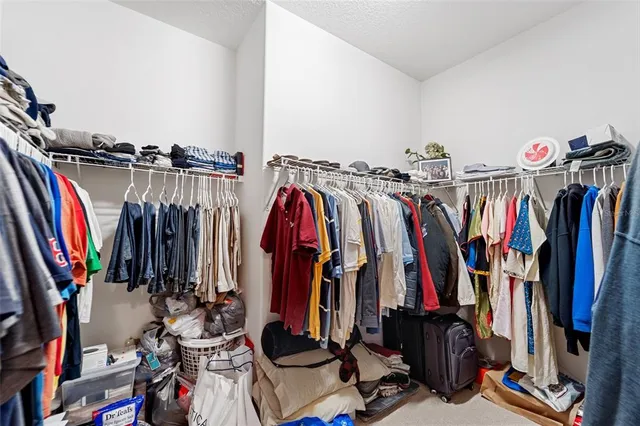 a view of walk in closet with clothes