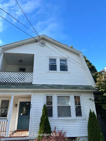 a front view of a house with plants