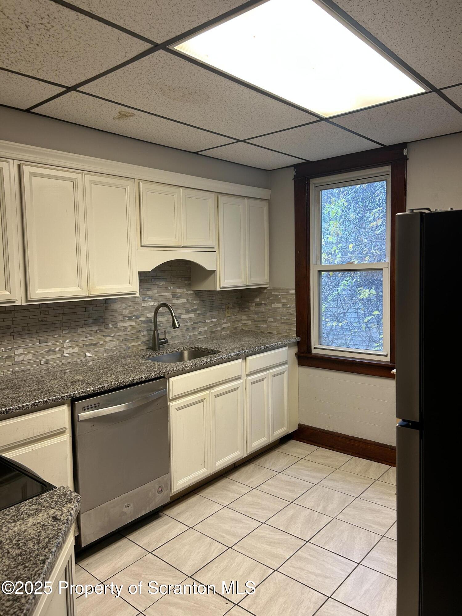 510 Moltke Avenue, Unit FIRST FLOOR #1 Scranton, PA 18505 - Photo 18 of 27 a kitchen with granite countertop a sink window and cabinets