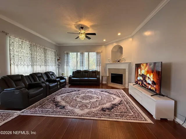a living room with furniture a flat screen tv and a fireplace