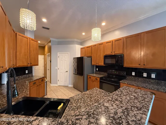 a kitchen with stainless steel appliances granite countertop a sink refrigerator and microwave
