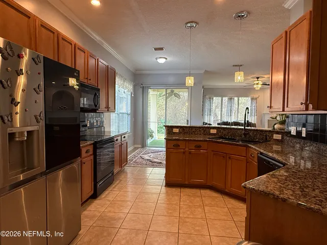 a large kitchen with granite countertop lots of counter space and stainless steel appliances