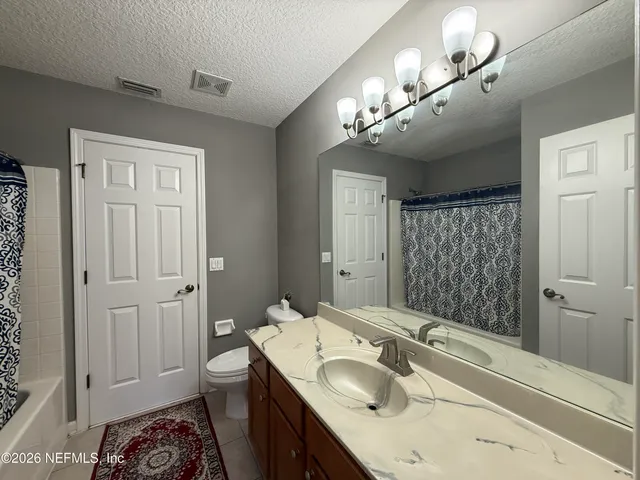 a bathroom with a sink a large mirror and a toilet