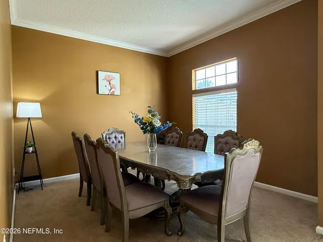 a view of a dining room with furniture and a window