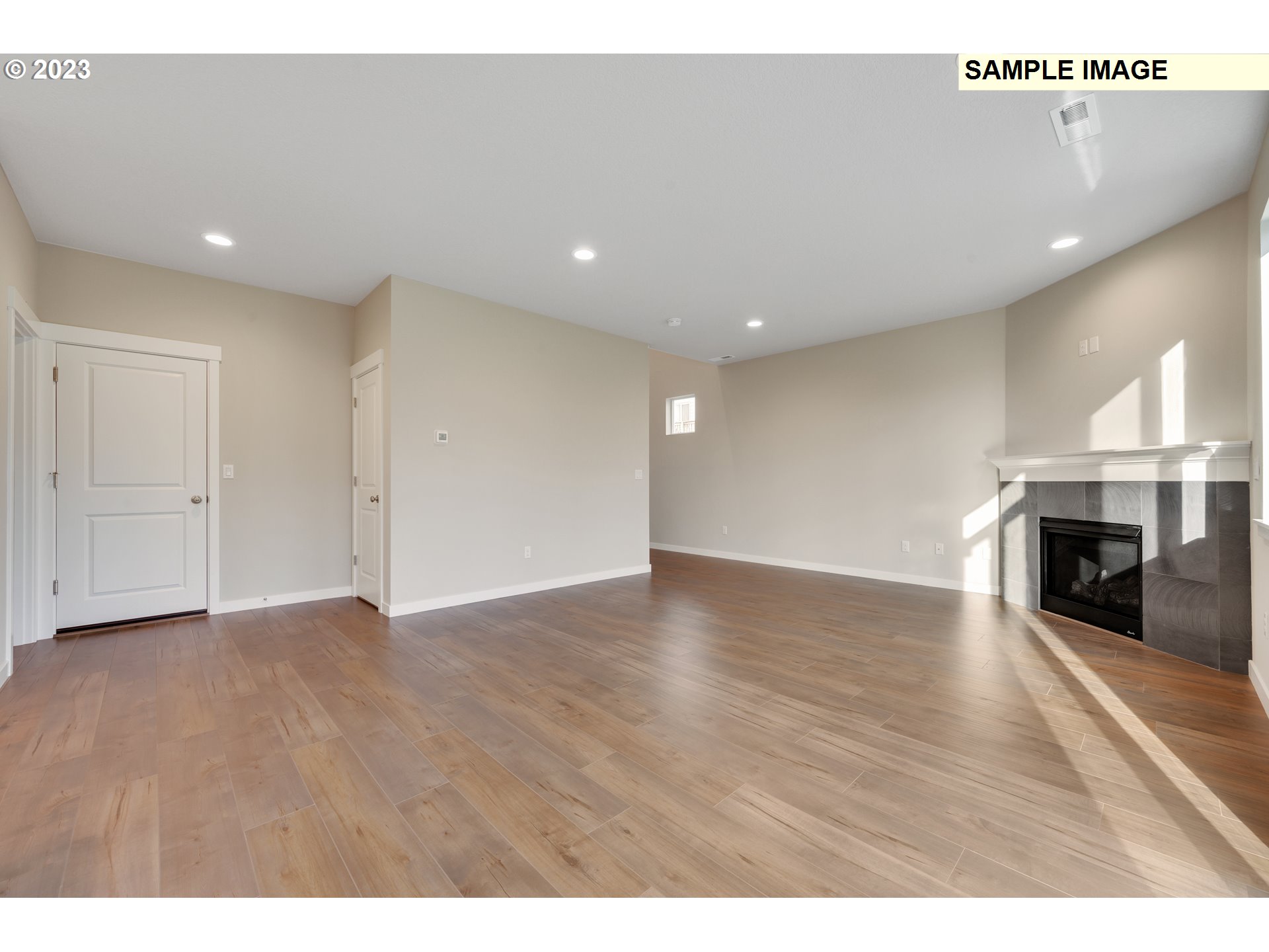 16881 Southeast Mist Layer Loop, Unit 531 Happy Valley, OR 97086 - Photo 22 of 32 a view of an empty room with wooden floor fireplace and a window