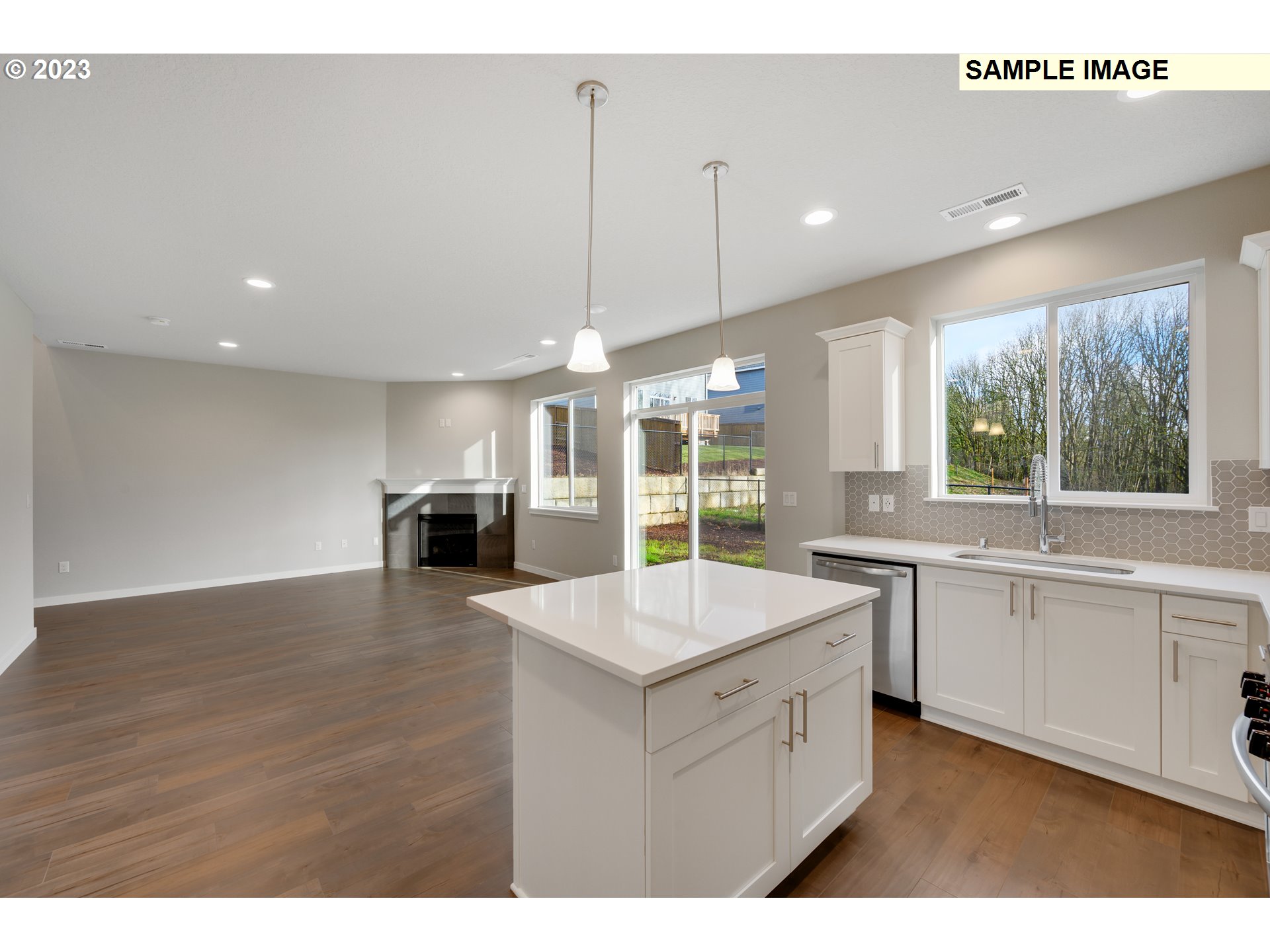 16881 Southeast Mist Layer Loop, Unit 531 Happy Valley, OR 97086 - Photo 27 of 32 a large white kitchen with a large island oven a sink stainless steel appliances and a couch