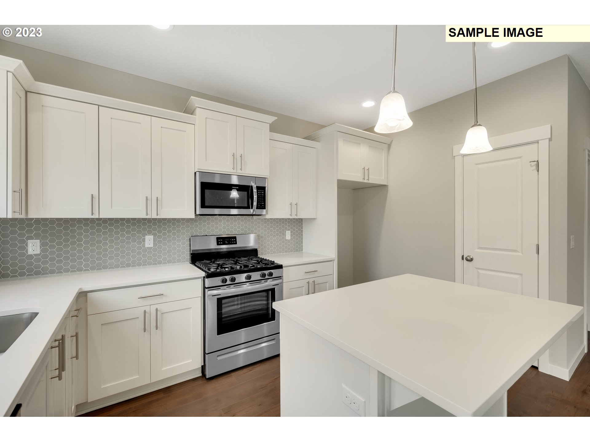 16881 Southeast Mist Layer Loop, Unit 531 Happy Valley, OR 97086 - Photo 3 of 32 a kitchen with a sink a microwave a stove and white cabinets