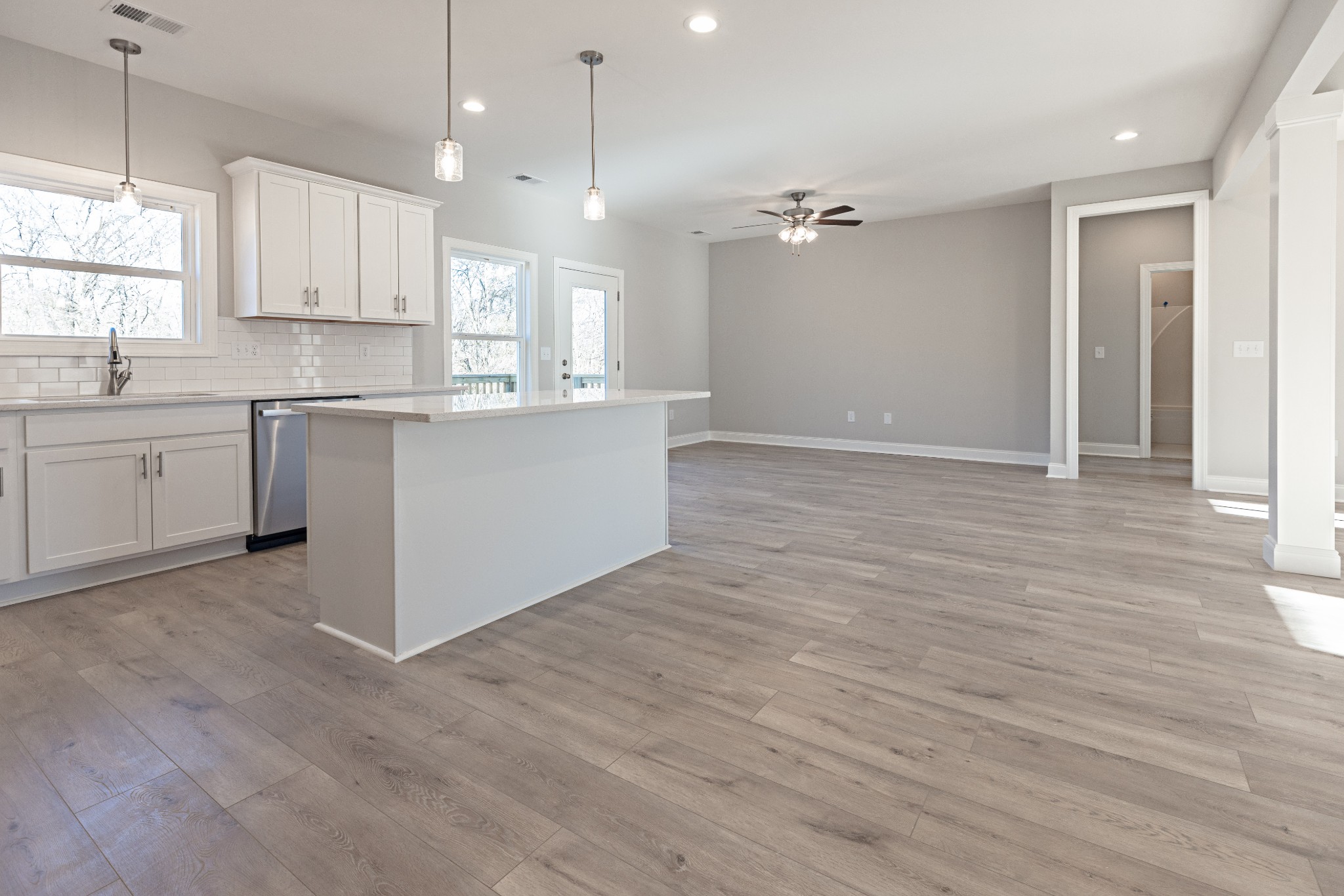 310 Woodruff Road Adams, TN 37010 - Photo 7 of 14 a large kitchen with granite countertop a stove top oven a sink and white cabinets with wooden floor