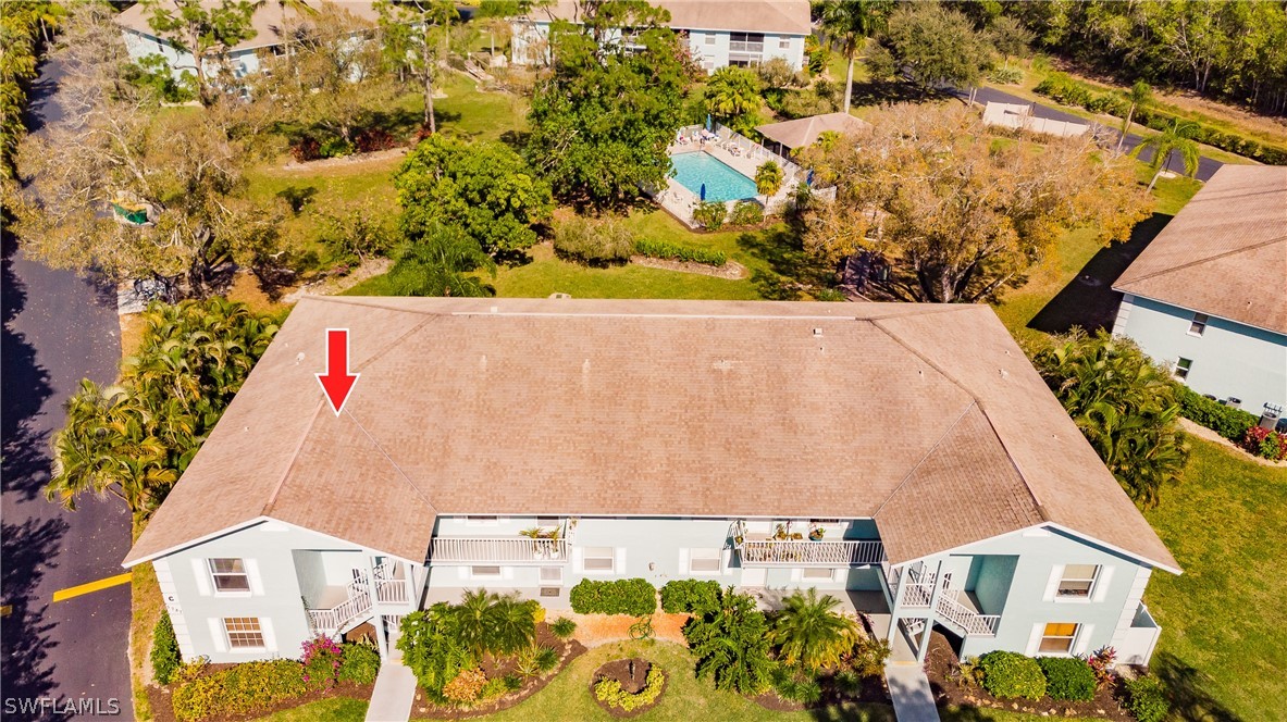 an aerial view of a multi story residential apartment building with a yard