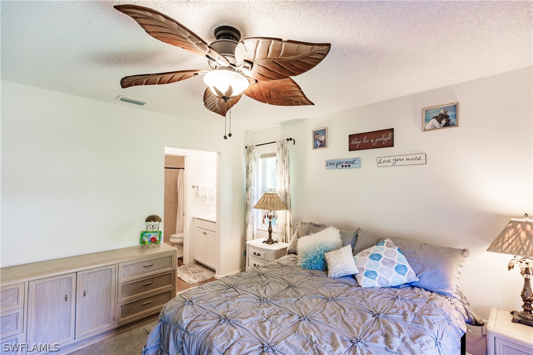 5737 Whitaker Road, Unit C201 Naples, FL 34112 - Photo 16 of 32 a bedroom with a bed and a chandelier