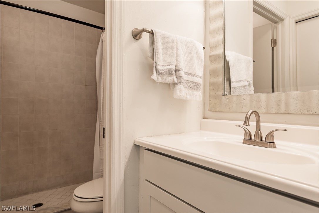 5737 Whitaker Road, Unit C201 Naples, FL 34112 - Photo 17 of 32 a bathroom with a sink and a mirror