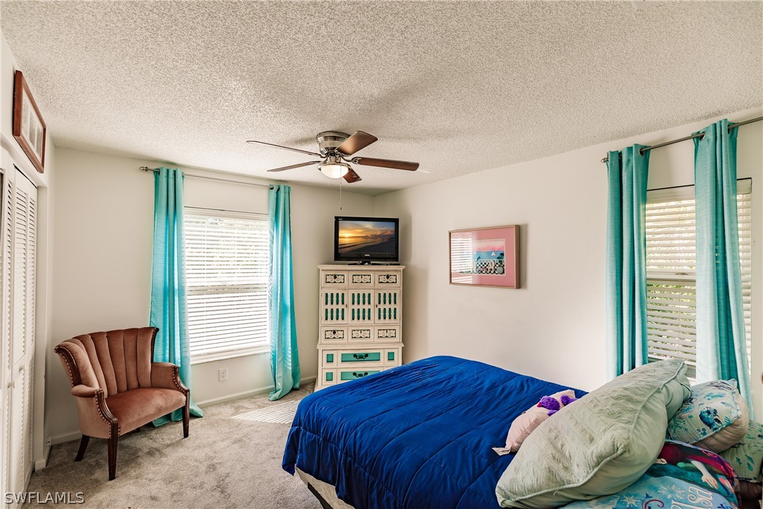 5737 Whitaker Road, Unit C201 Naples, FL 34112 - Photo 18 of 32 a bedroom with a large bed and a window