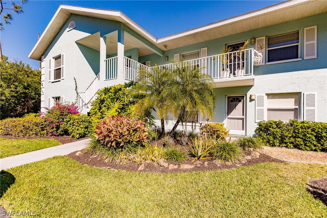 5737 Whitaker Road, Unit C201 Naples, FL 34112 - Photo 2 of 32 a front view of a house with a yard