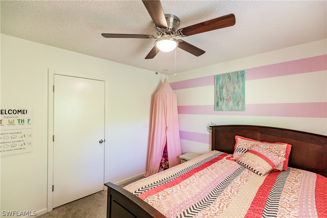 5737 Whitaker Road, Unit C201 Naples, FL 34112 - Photo 23 of 32 a bedroom with a bed and a chandelier