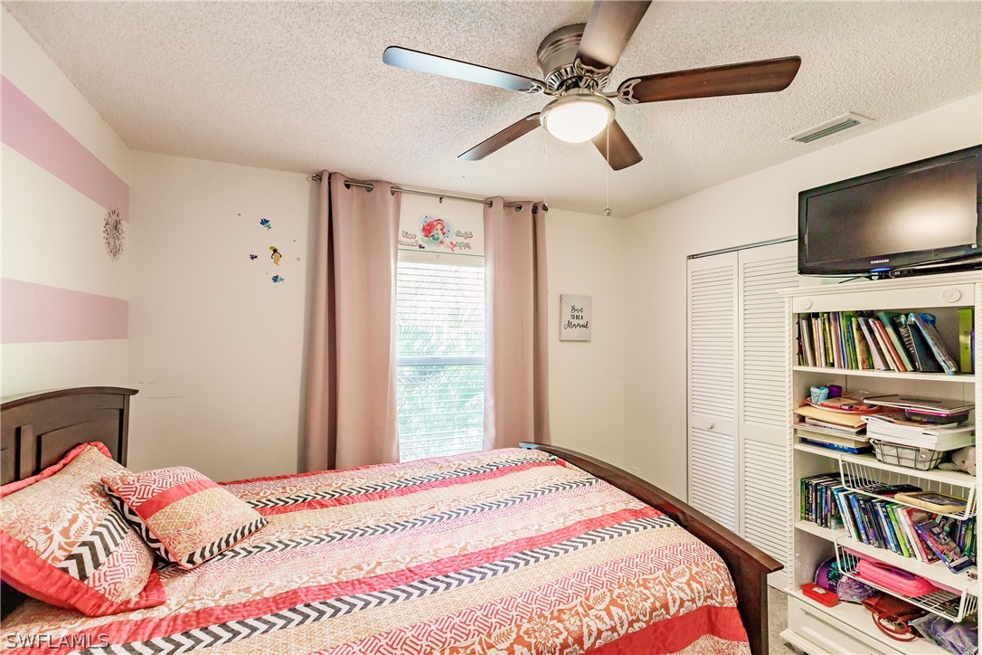 5737 Whitaker Road, Unit C201 Naples, FL 34112 - Photo 24 of 32 a bedroom with a bed and a flat screen tv