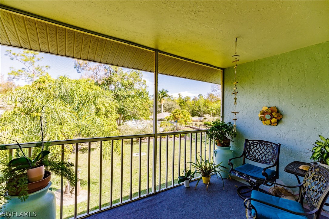 5737 Whitaker Road, Unit C201 Naples, FL 34112 - Photo 26 of 32 a view of a chairs and table in the balcony
