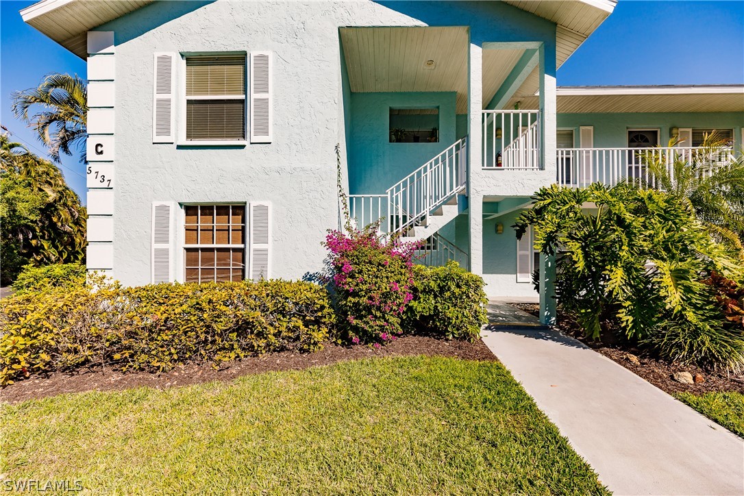 5737 Whitaker Road, Unit C201 Naples, FL 34112 - Photo 3 of 32 a view of a house with a yard and garden