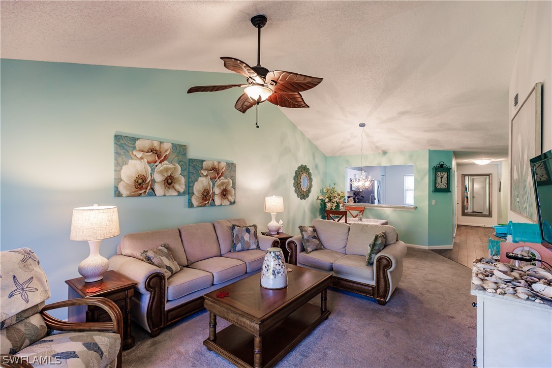 5737 Whitaker Road, Unit C201 Naples, FL 34112 - Photo 5 of 32 a living room with furniture a couch and a chandelier