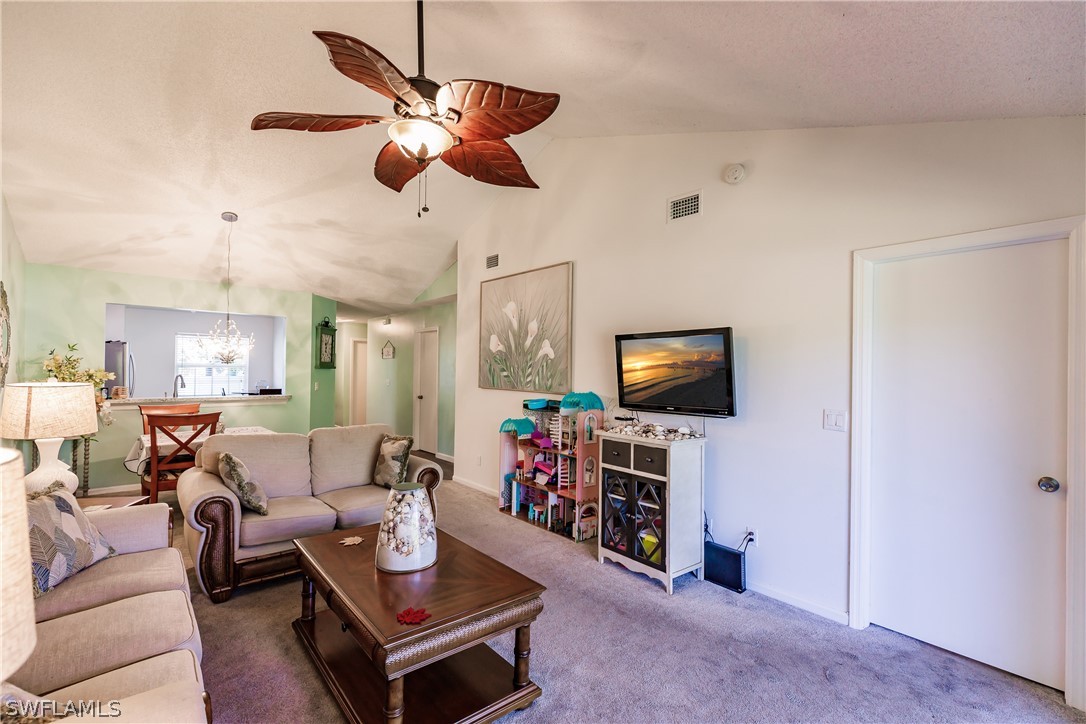 5737 Whitaker Road, Unit C201 Naples, FL 34112 - Photo 6 of 32 a living room with furniture a flat screen tv and a window