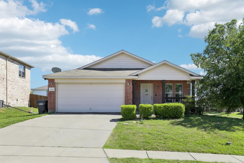 Single story home with a front lawn, brick siding, and a garage