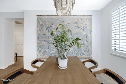 a vase of flowers sitting on a table with a potted plant