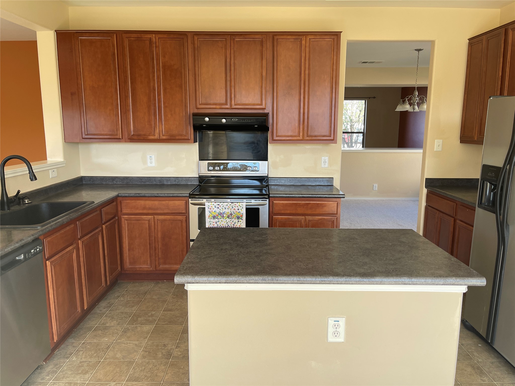 160 Mistletoe Lane Kyle, TX 78640 - Photo 21 of 29 a kitchen with kitchen island a sink a stove and wooden cabinets