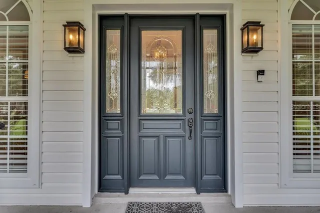a view of an empty room with wooden floor and windows