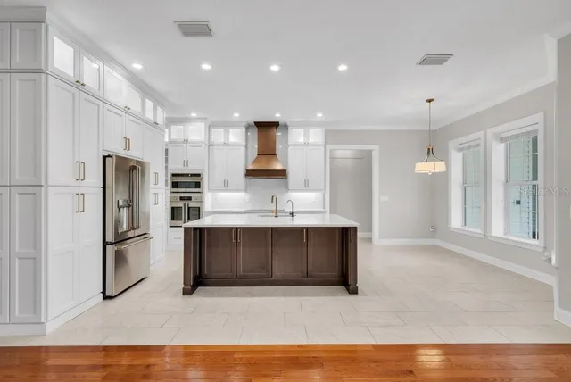 a spacious bathroom with a granite countertop tub a double vanity sink a vanity a window and a mirror