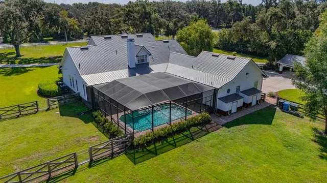 an aerial view of a house with swimming pool and ocean view