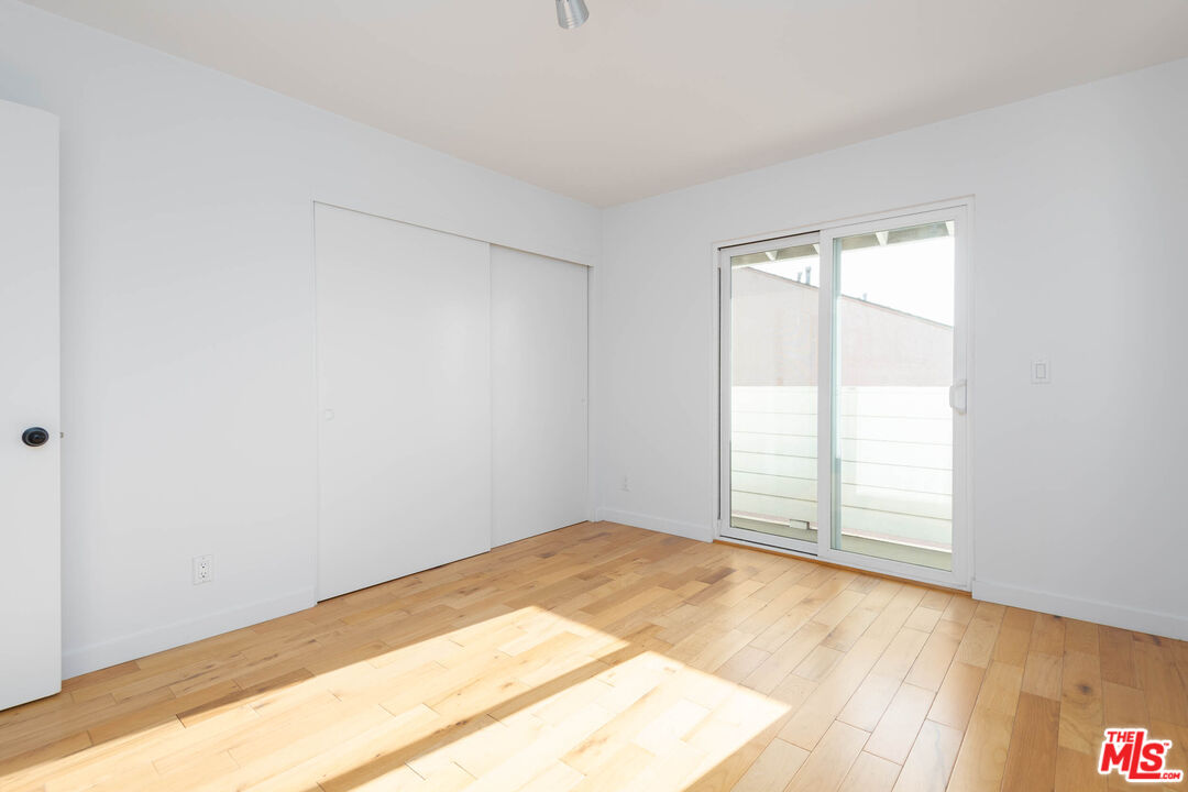 1016 Sanborn Avenue, Unit 101 Los Angeles, CA 90029 - Photo 11 of 18 an empty room with wooden floor and windows