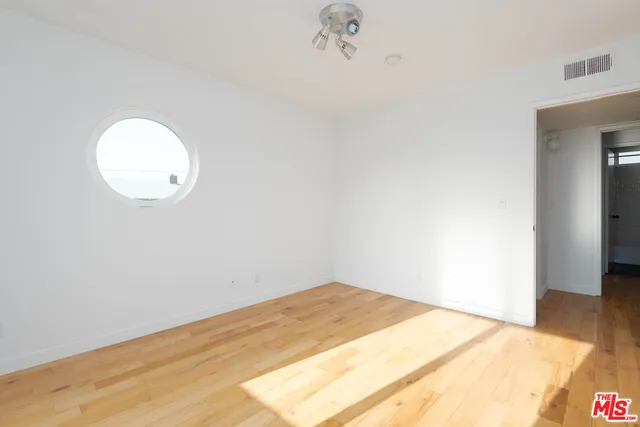 a view of a room with wooden floor and a ceiling fan