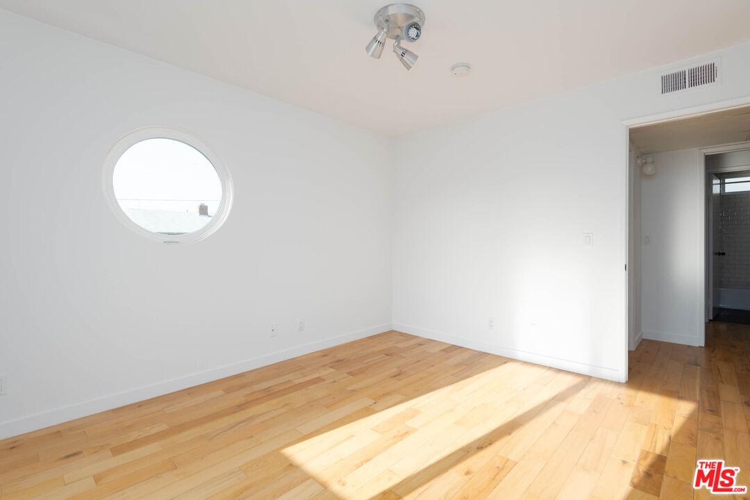1016 Sanborn Avenue, Unit 101 Los Angeles, CA 90029 - Photo 12 of 18 a view of a room with wooden floor and a ceiling fan