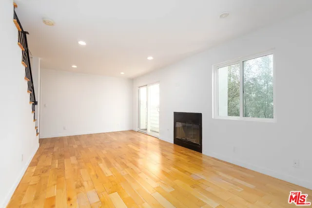 a view of an empty room with a fireplace and a window