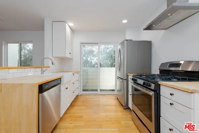 a kitchen with granite countertop a sink stove and refrigerator
