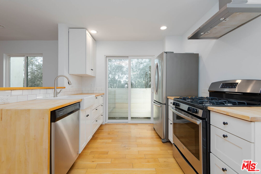 1016 Sanborn Avenue, Unit 101 Los Angeles, CA 90029 - Photo 4 of 18 a kitchen with granite countertop a sink stove and refrigerator