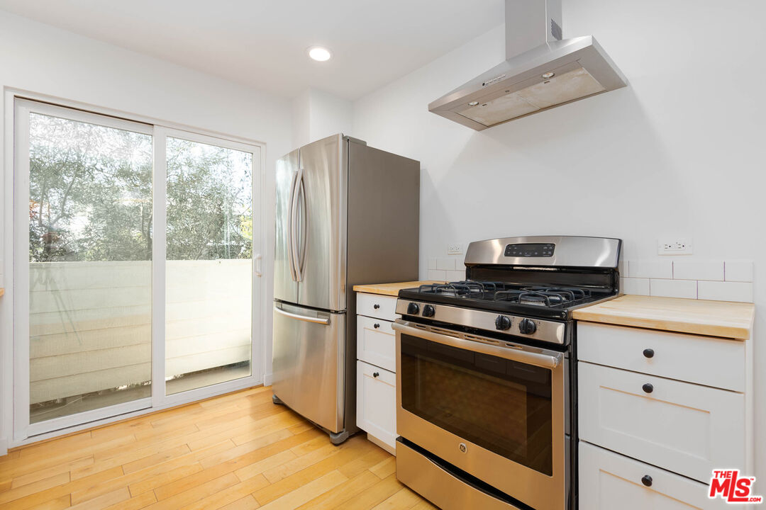 1016 Sanborn Avenue, Unit 101 Los Angeles, CA 90029 - Photo 5 of 18 a kitchen with a stove top oven and refrigerator