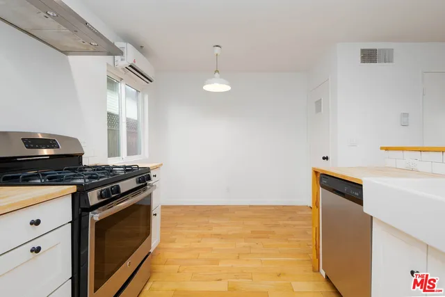 a kitchen with granite countertop stainless steel appliances and wooden floor