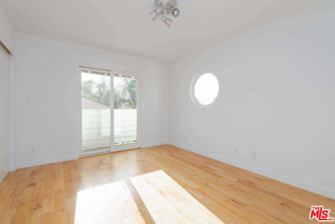 1016 Sanborn Avenue, Unit 101 Los Angeles, CA 90029 - Photo 10 of 18 a view of an empty room with wooden floor and a window