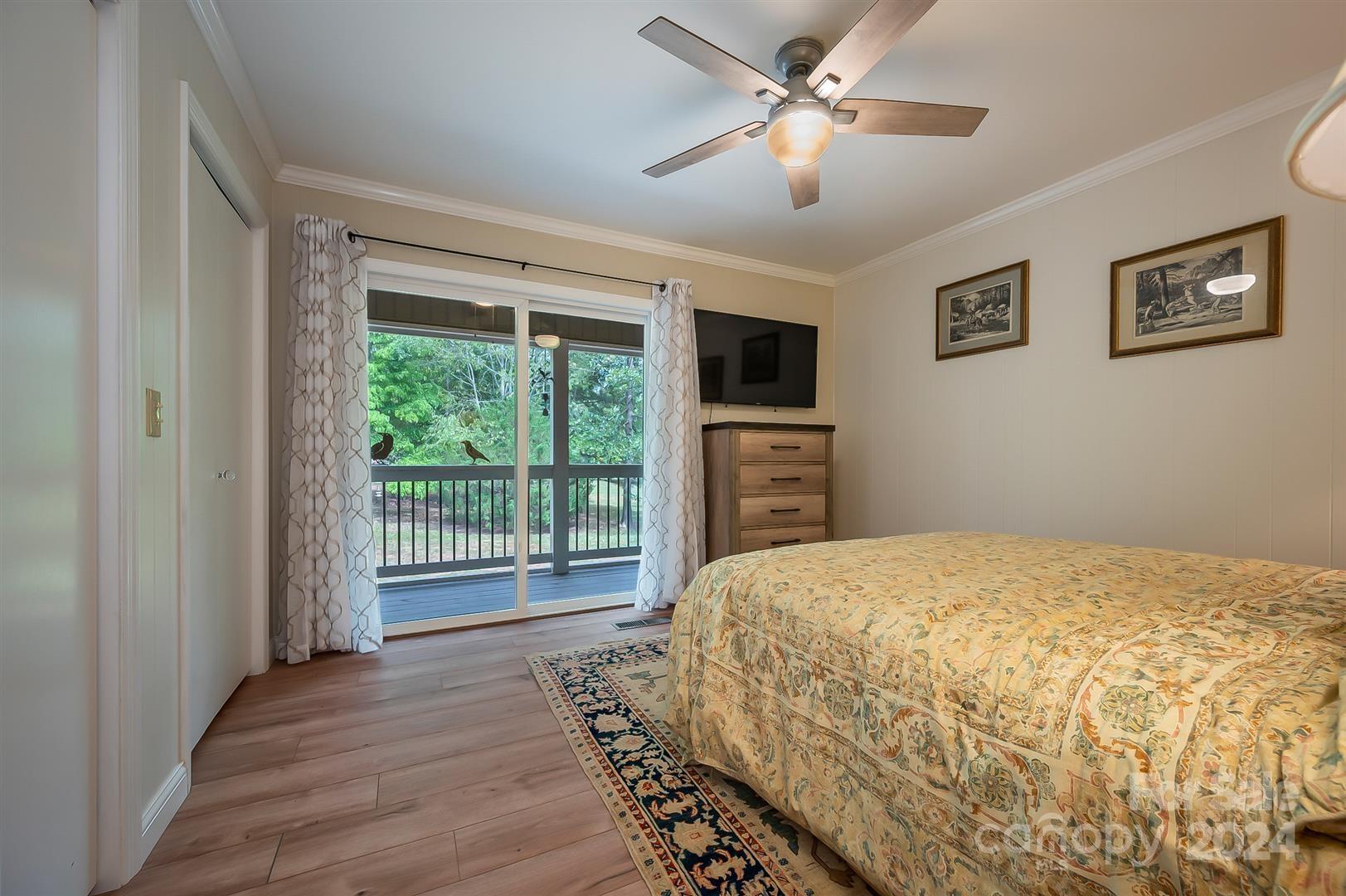 2316 Golf Course Road Columbus, NC 28722 - Photo 16 of 33 a bedroom with a large bed and a chandelier