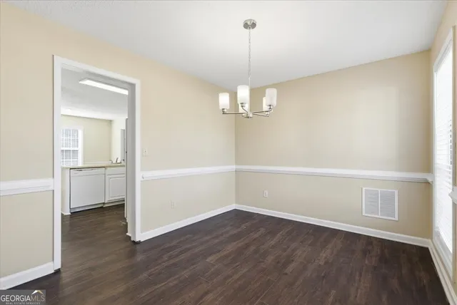 a view of empty room with wooden floor and window