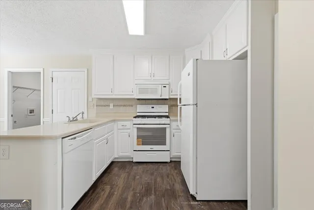a kitchen with stainless steel appliances white cabinets and a refrigerator