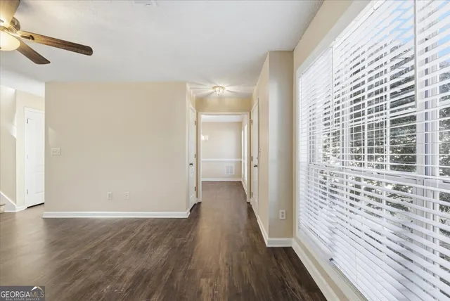 a view of a hallway with wooden floor and staircase