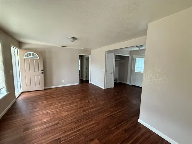 a view of a livingroom with wooden floor and staircase