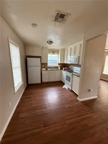 a kitchen with a wooden floor and a stove top oven