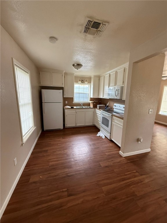 308 East 2nd Street Bishop, TX 78343 - Photo 4 of 12 a kitchen with a wooden floor and a stove top oven