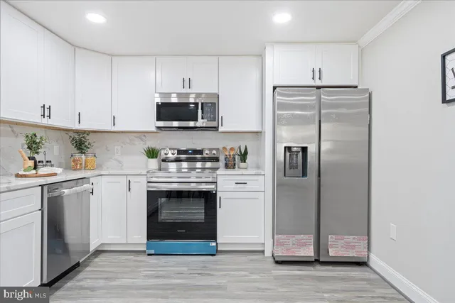 a kitchen with cabinets stainless steel appliances and a counter space