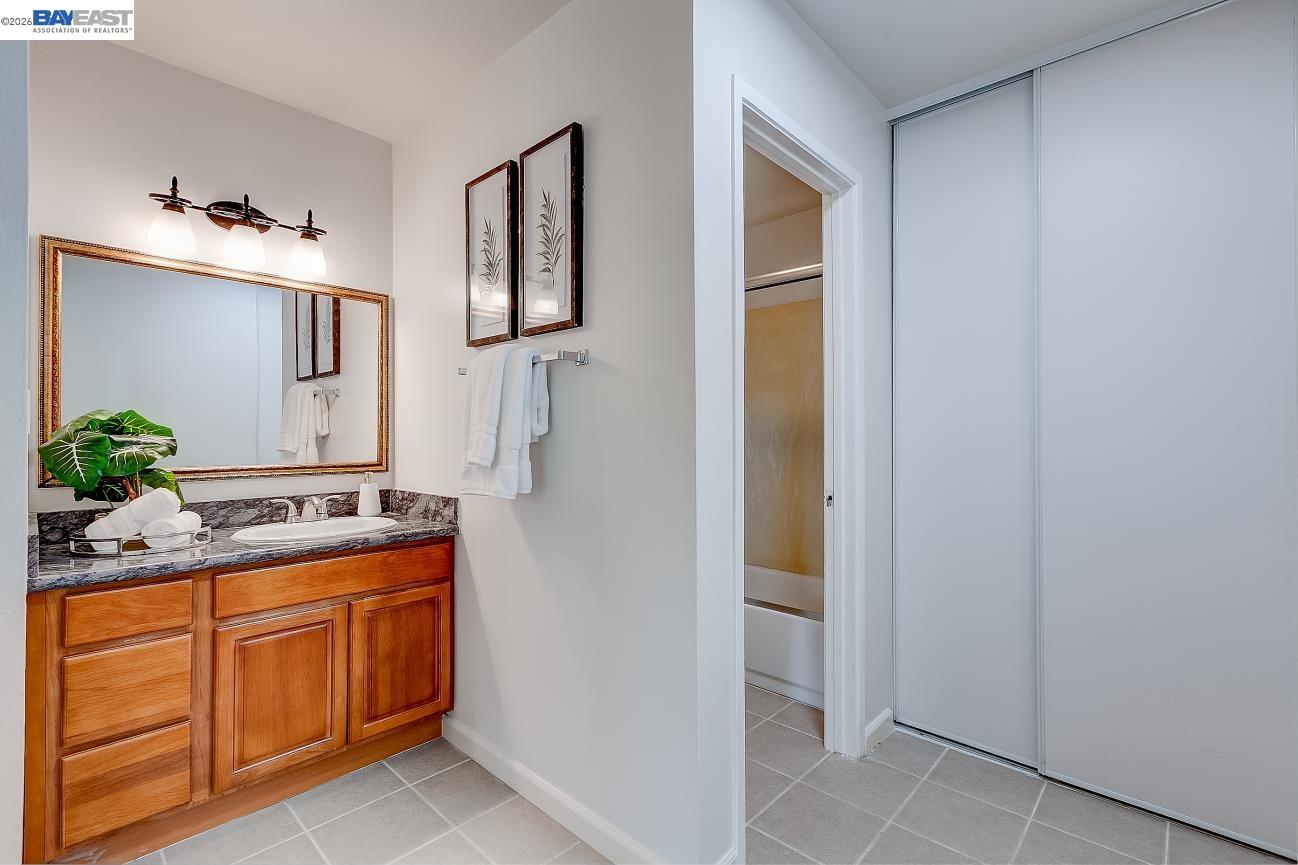 9005 Alcosta Boulevard, Unit 199 San Ramon, CA 94583 - Photo 46 of 57 a bathroom with a granite countertop sink and a mirror